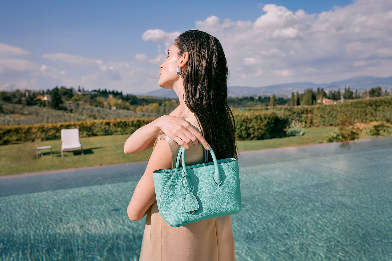 Elegant woman carrying a BONAVENTURA handcrafted summer leather bag in vibrant summer color