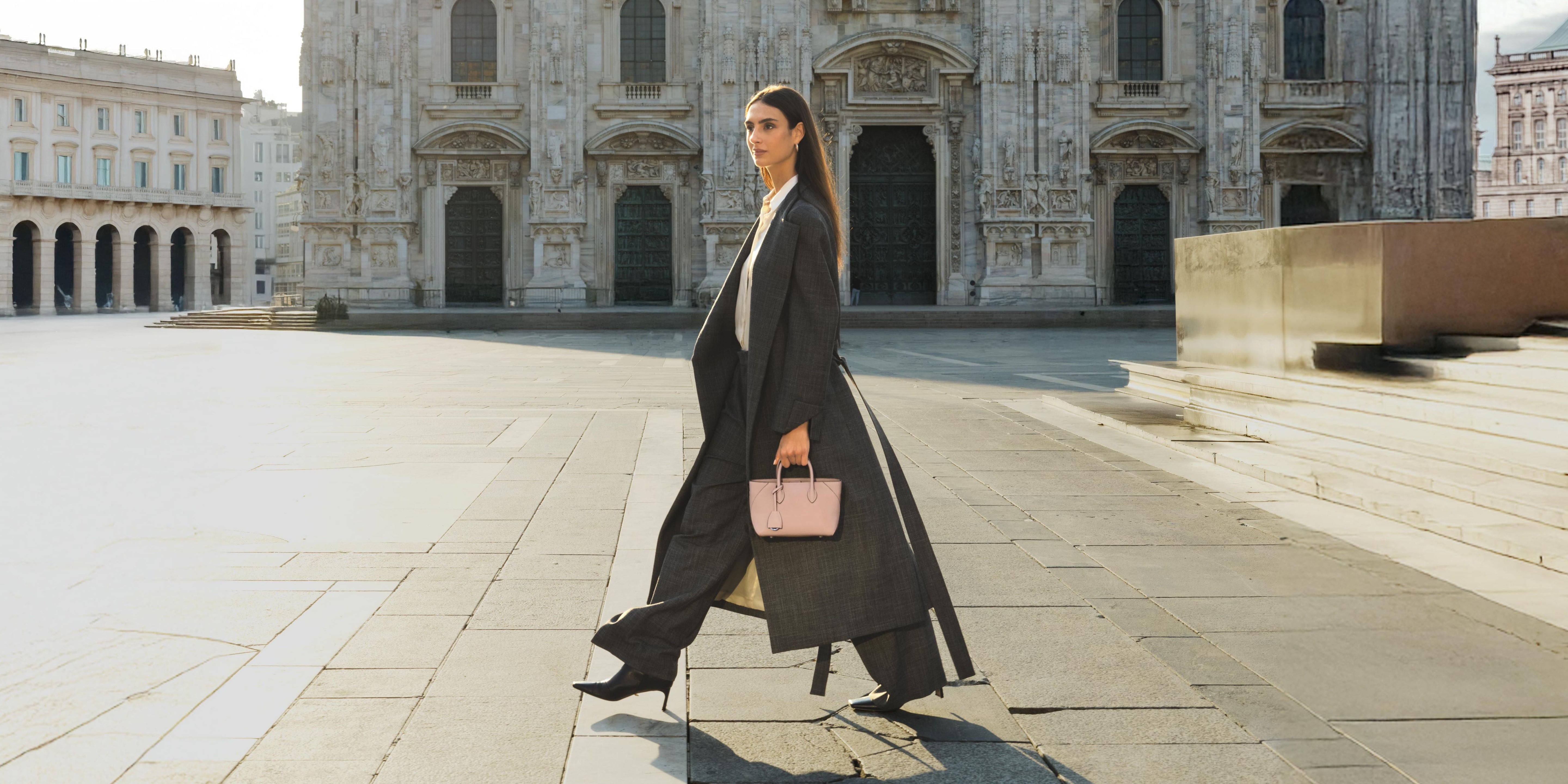 Elegant woman carrying the BONAVENTURA Mini Mia Tote Bag in Almond Pink from the Veli di Luce Collection in front of the Duomo di Milano.
