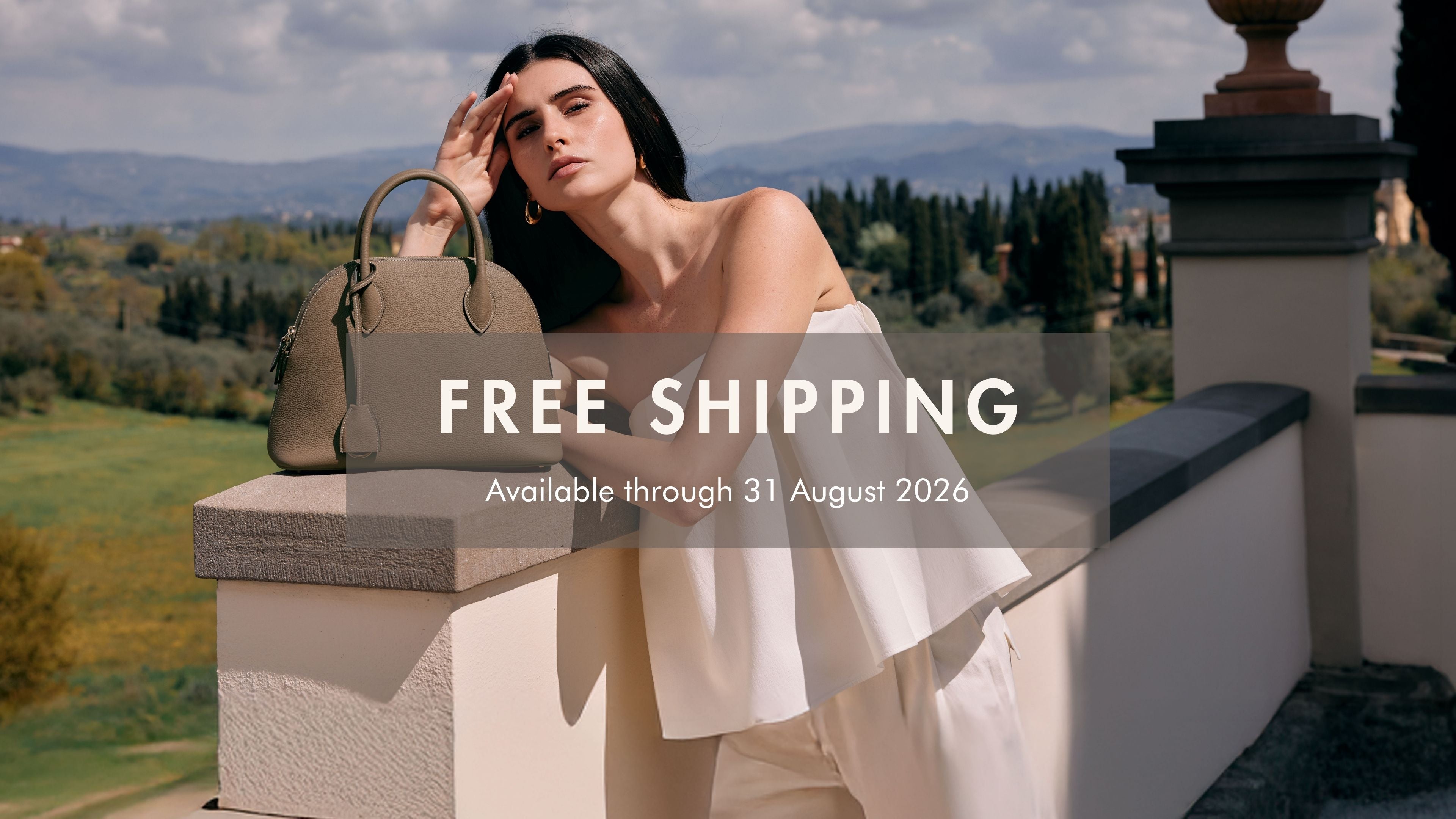 Woman carrying a BONAVENTURA leather bag in a Mediterranean summer setting