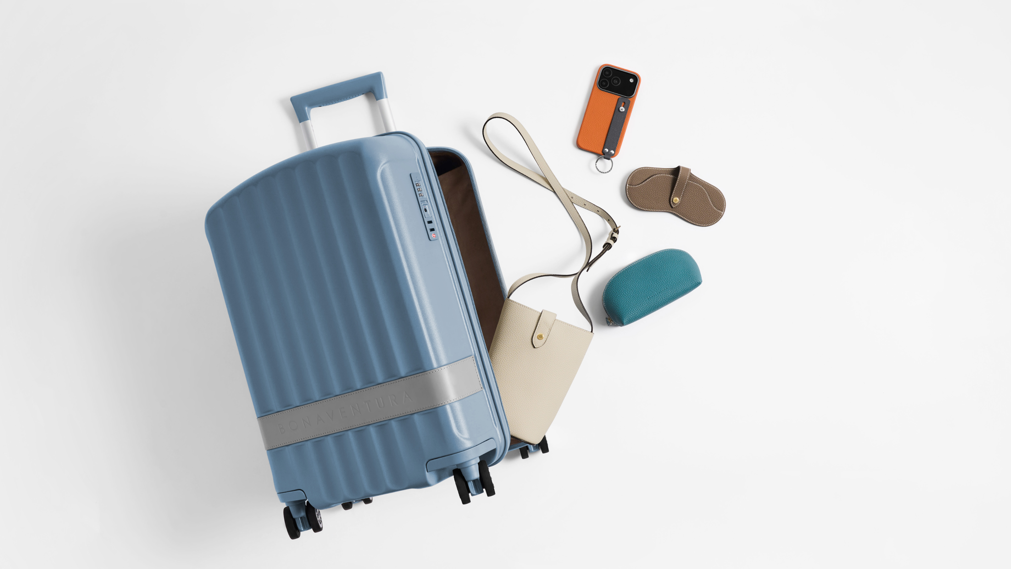 Lightweight luxury cabin suitcase styled with elegant leather travel essentials for refined summer travel.